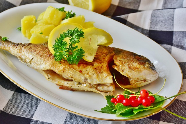 Prato Peixe com limão e folhas verdes.