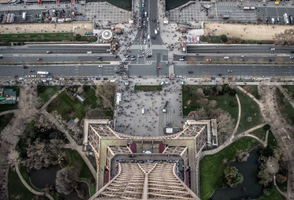 Foto da base da Torre Eiffel, pessoas em volta.
