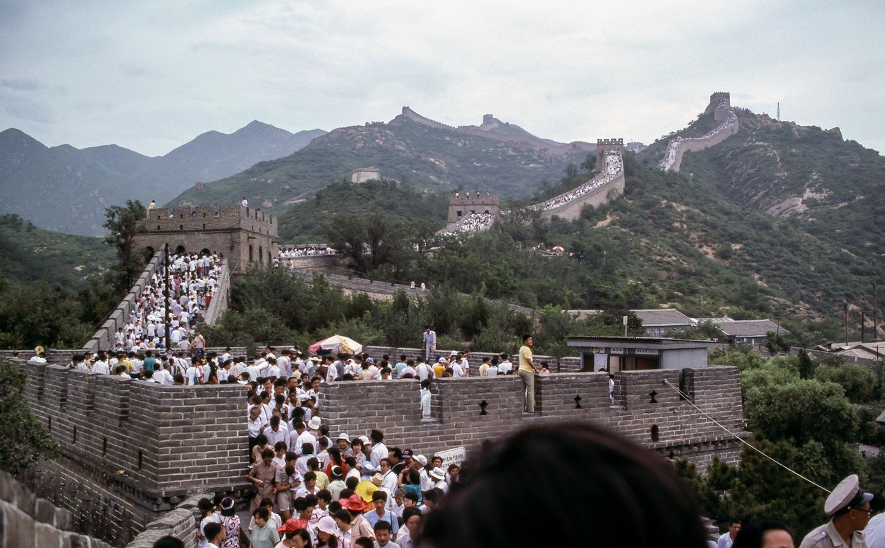 Turistas caminhando sobre a Grande Muralha da China em dia ensolarado