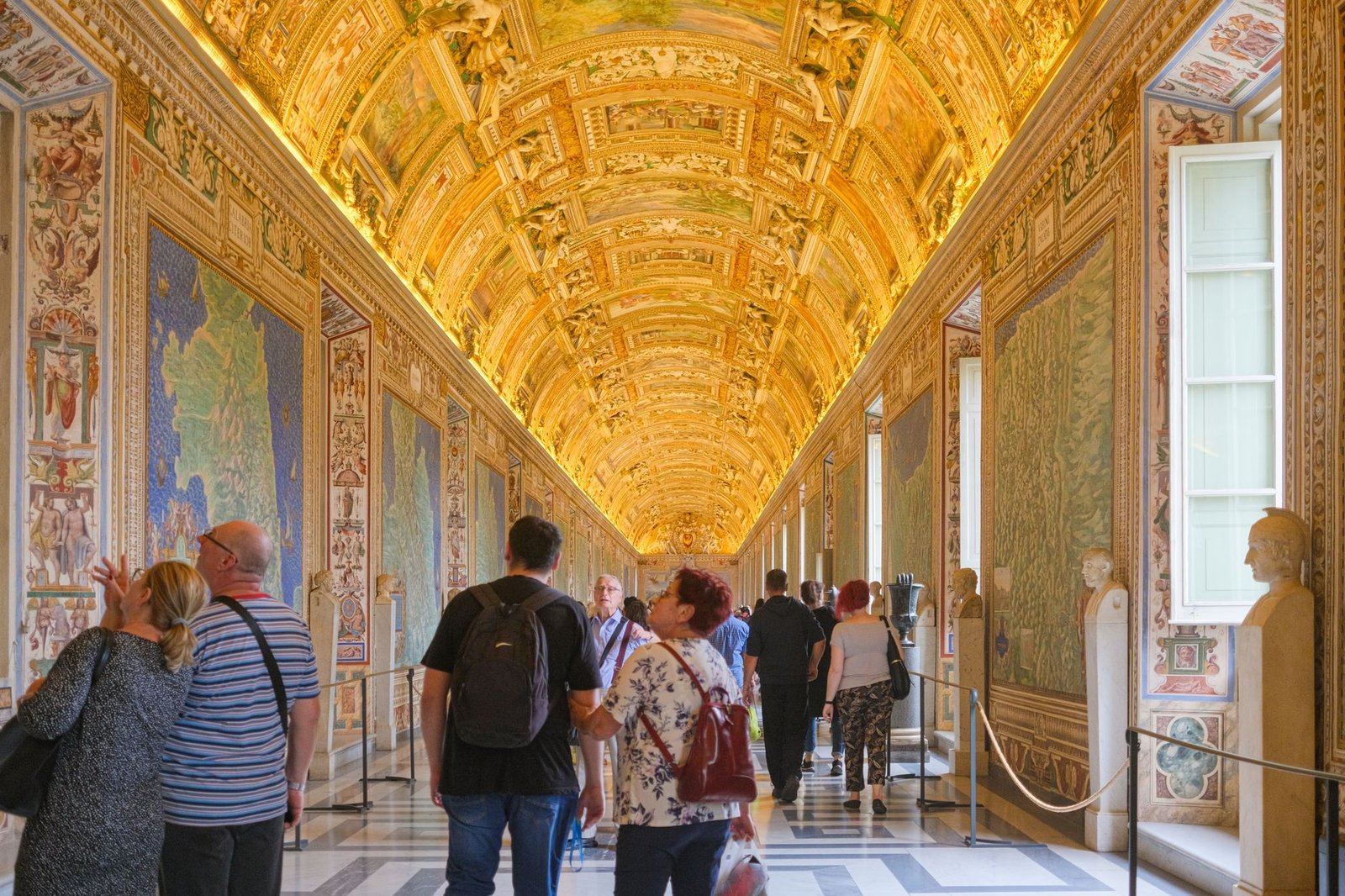 Couloir de la Galerie des Cartes Géographiques aux Musées du Vatican avec plafond décoré et panneaux cartographiques