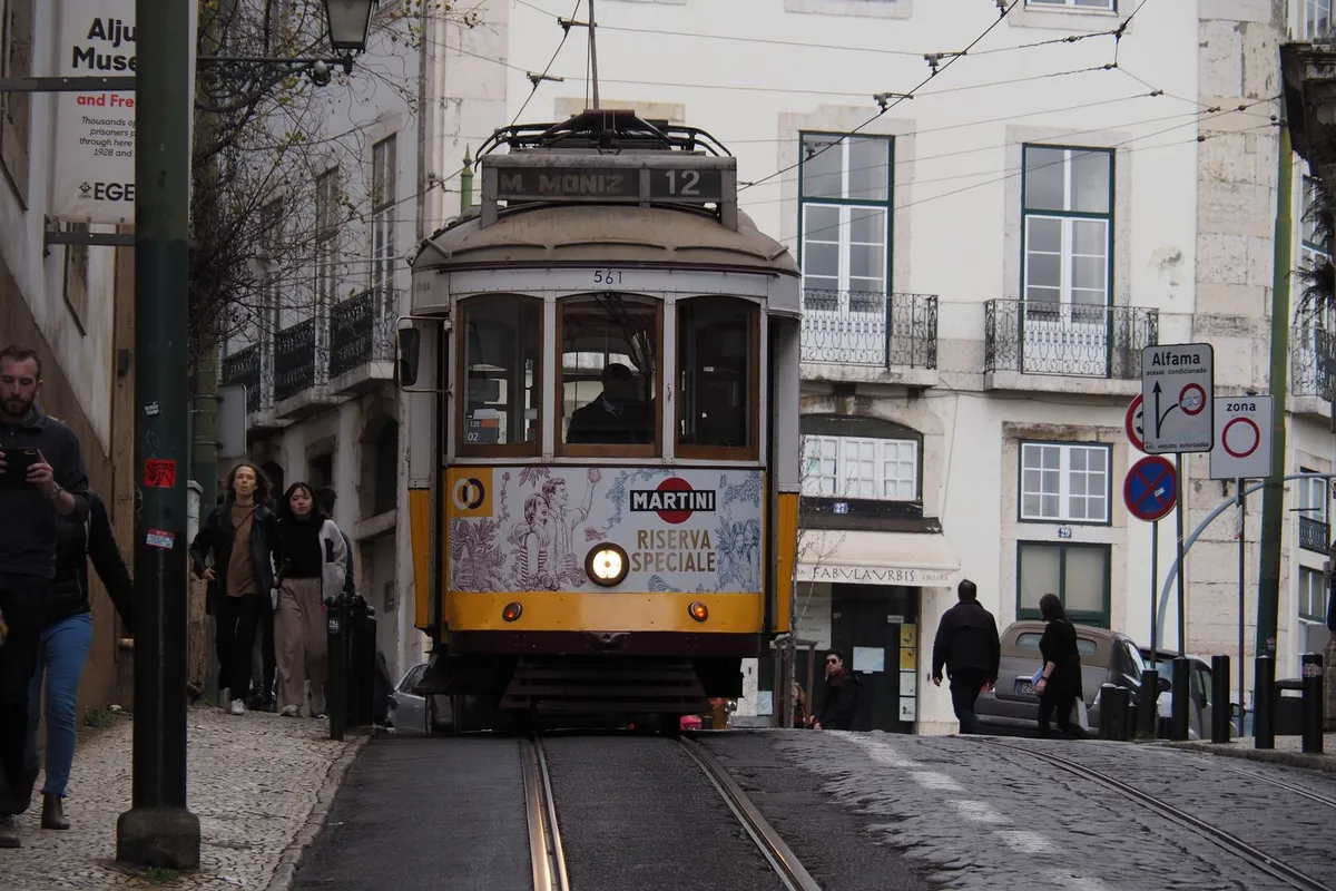 Elétrico amarelo no bairro de Alfama em Lisboa