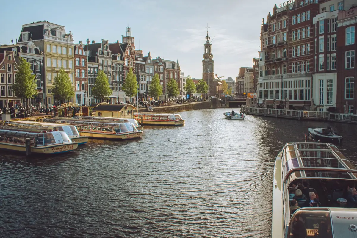 Canal de Amsterdã com torre de igreja ao fundo