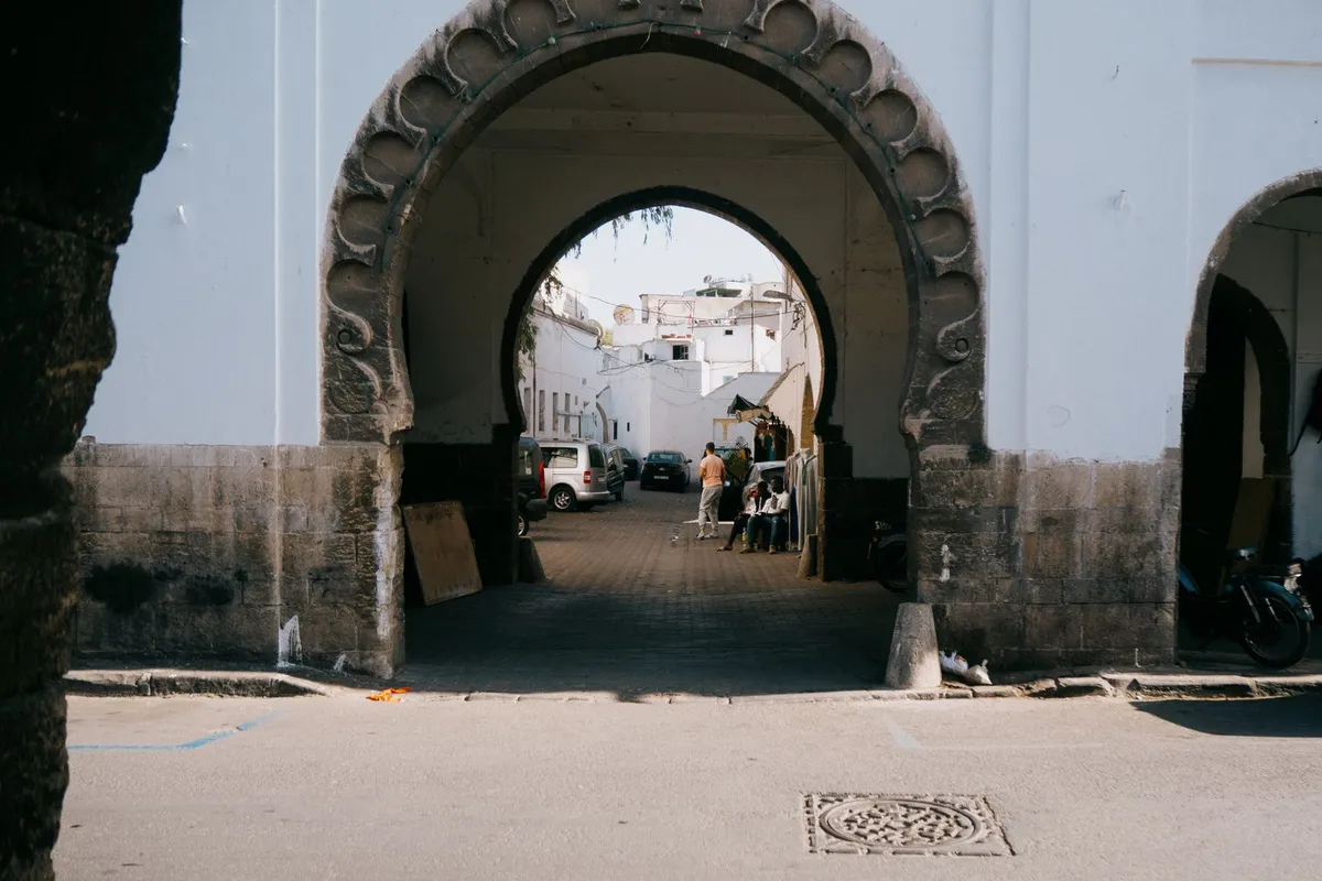 Arco em estilo mouresque com azulejos e portão entalhado em bairro tradicional de Casablanca.