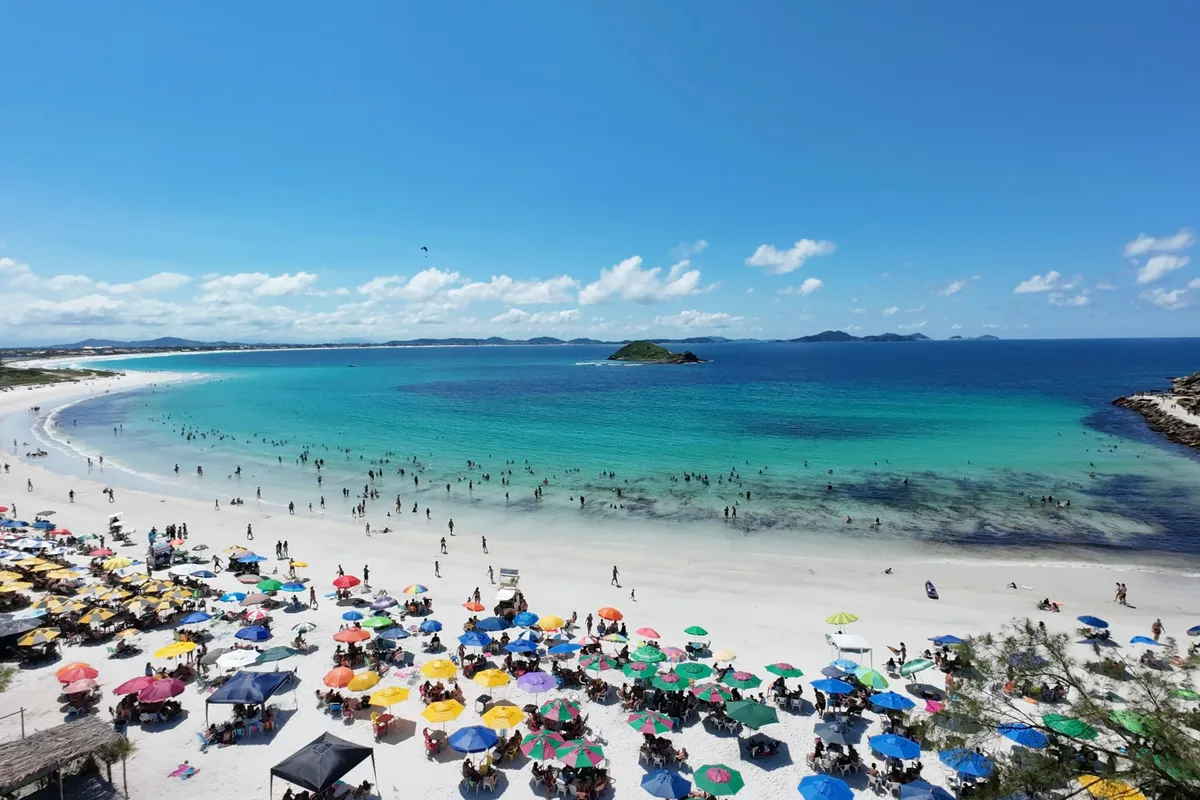Faixa de areia e mar azul em Arraial do Cabo