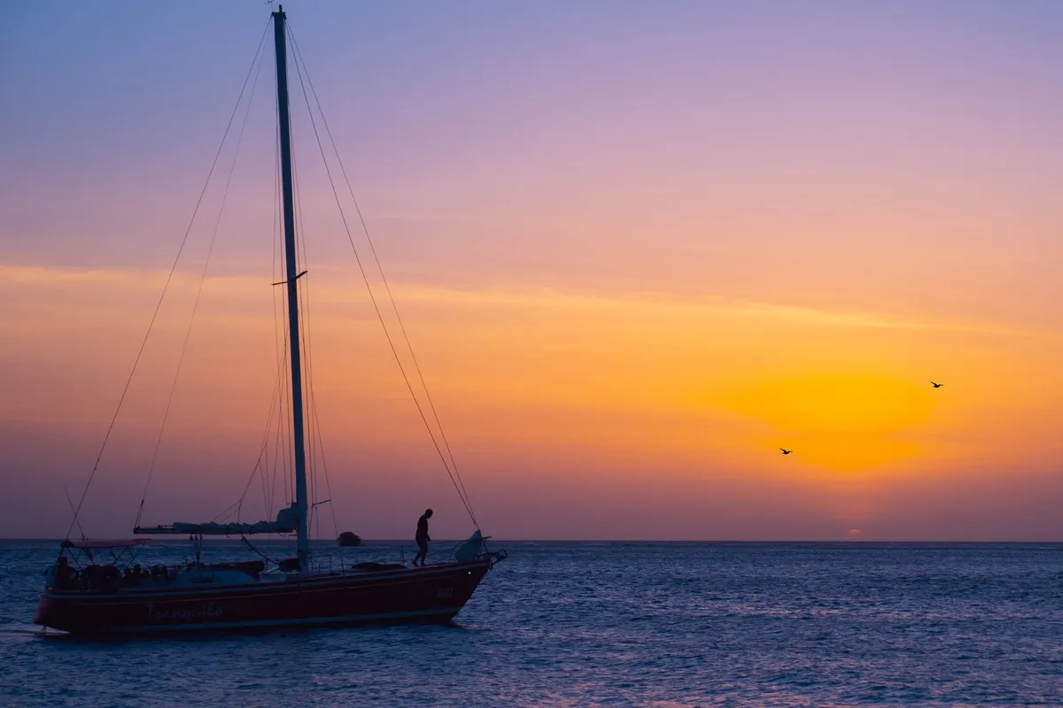 Catamarã navegando ao entardecer na costa de Aruba, perto de Oranjestad