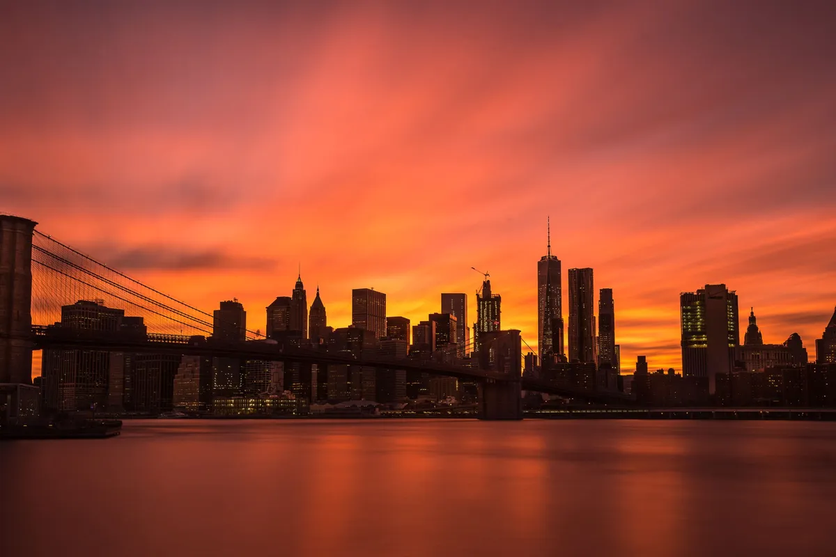 Vista do Brooklyn Bridge ao pôr do sol com o skyline de Manhattan
