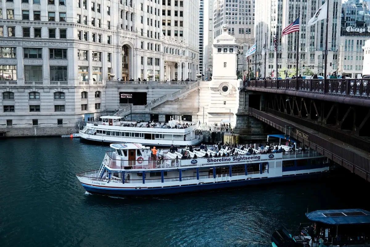 Barco de passeio turístico navegando pelo Chicago River entre arranha-céus