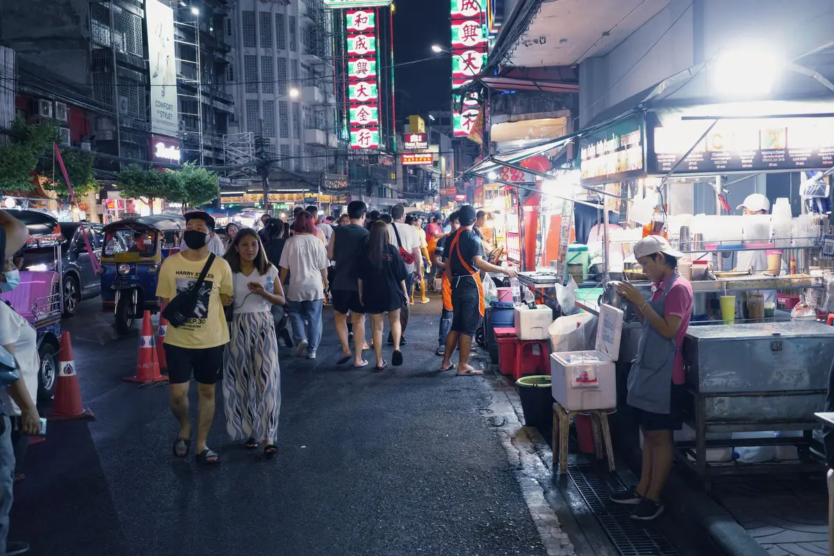 Rua movimentada de Chinatown em Bangkok com barracas e neon