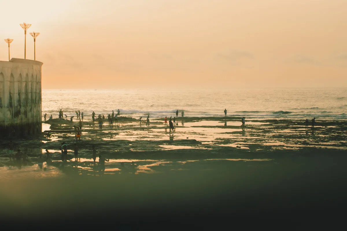 Costa da Corniche em Casablanca com sol se pondo sobre o Oceano Atlântico.