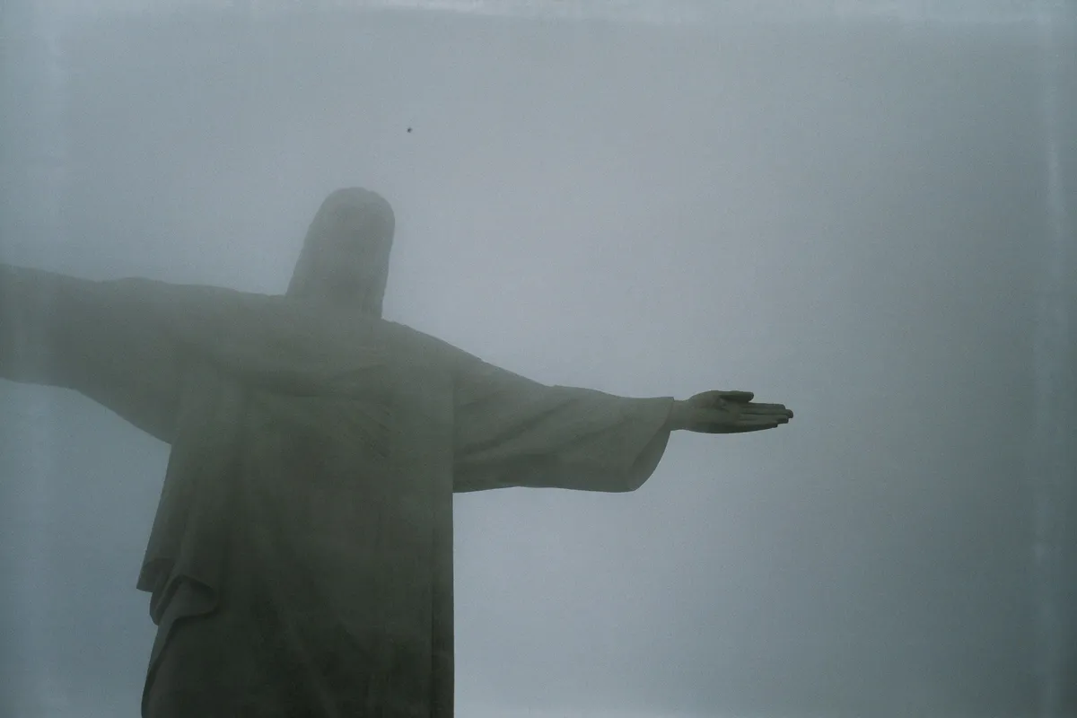 Cristo Redentor parcialmente encoberto por neblina e nuvens baixas