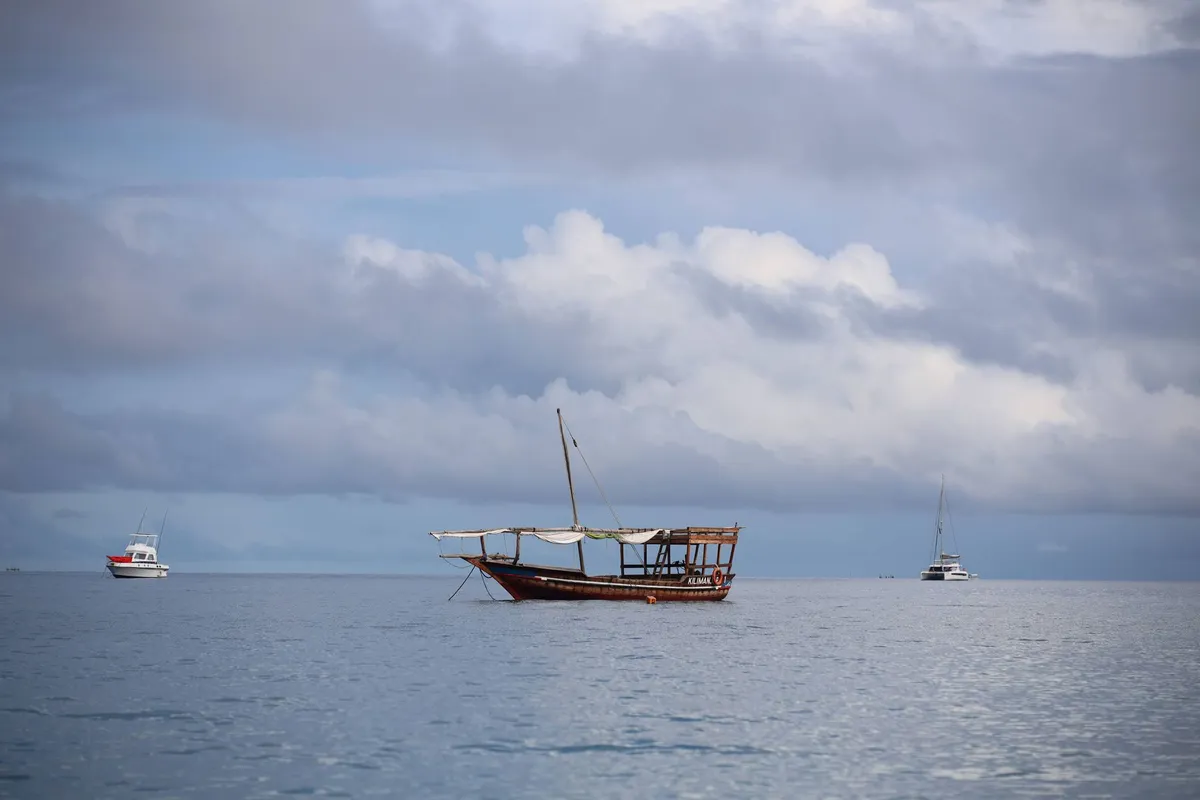 Dhow, veleiro tradicional, navegando nas águas azuis de Zanzibar
