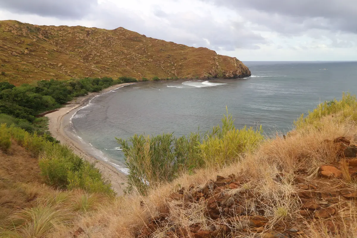 Enseada cercada de morros verdes em uma das praias da Interpraias