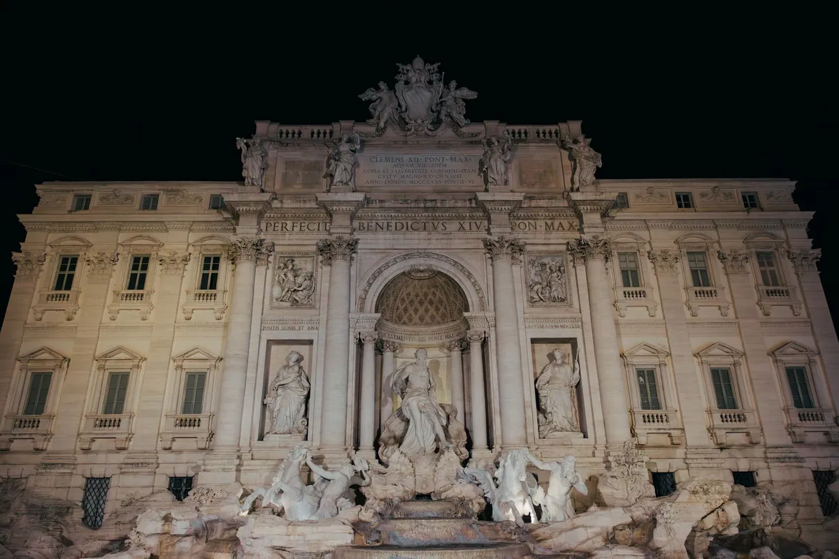 Fontana di Trevi iluminada durante a noite em Roma