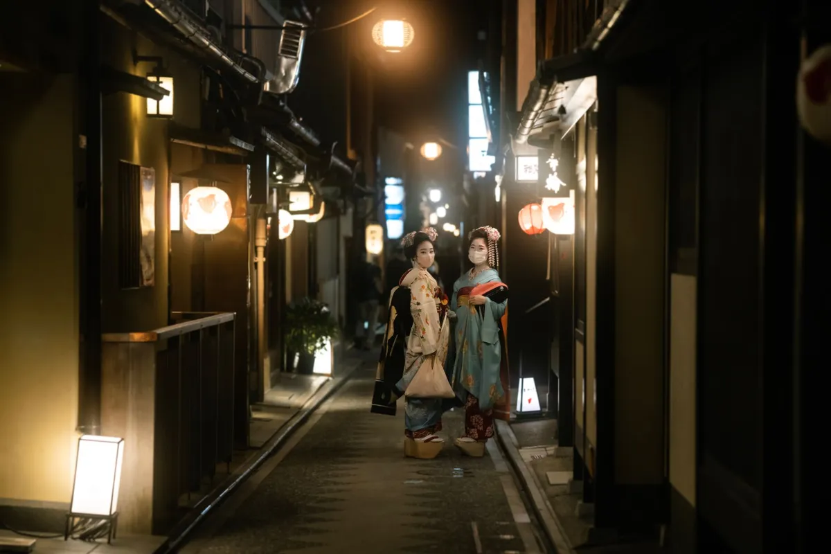 Duas pessoas de quimono caminhando por rua estreita em Gion, Kyoto