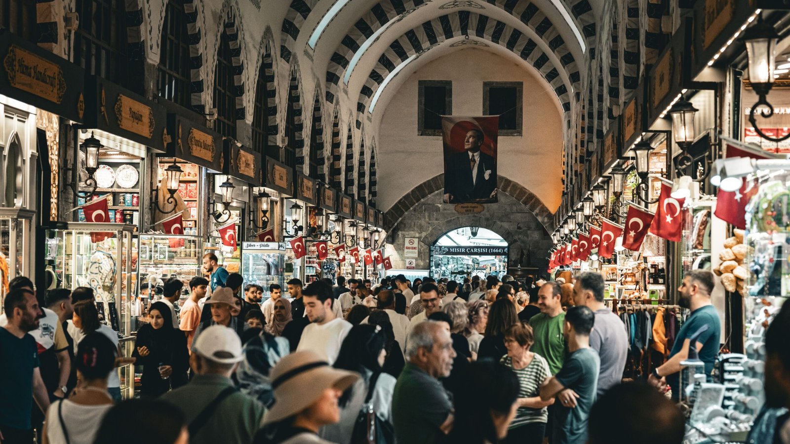Corredor movimentado do Grand Bazaar em Istambul com bandeiras turcas