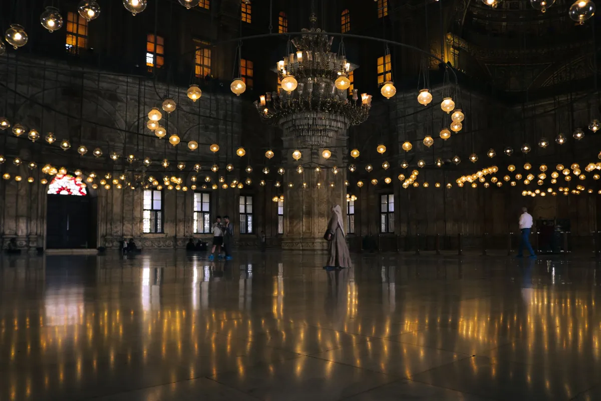Interior da Mesquita de Muhammad Ali com cúpulas e lustres no Cairo