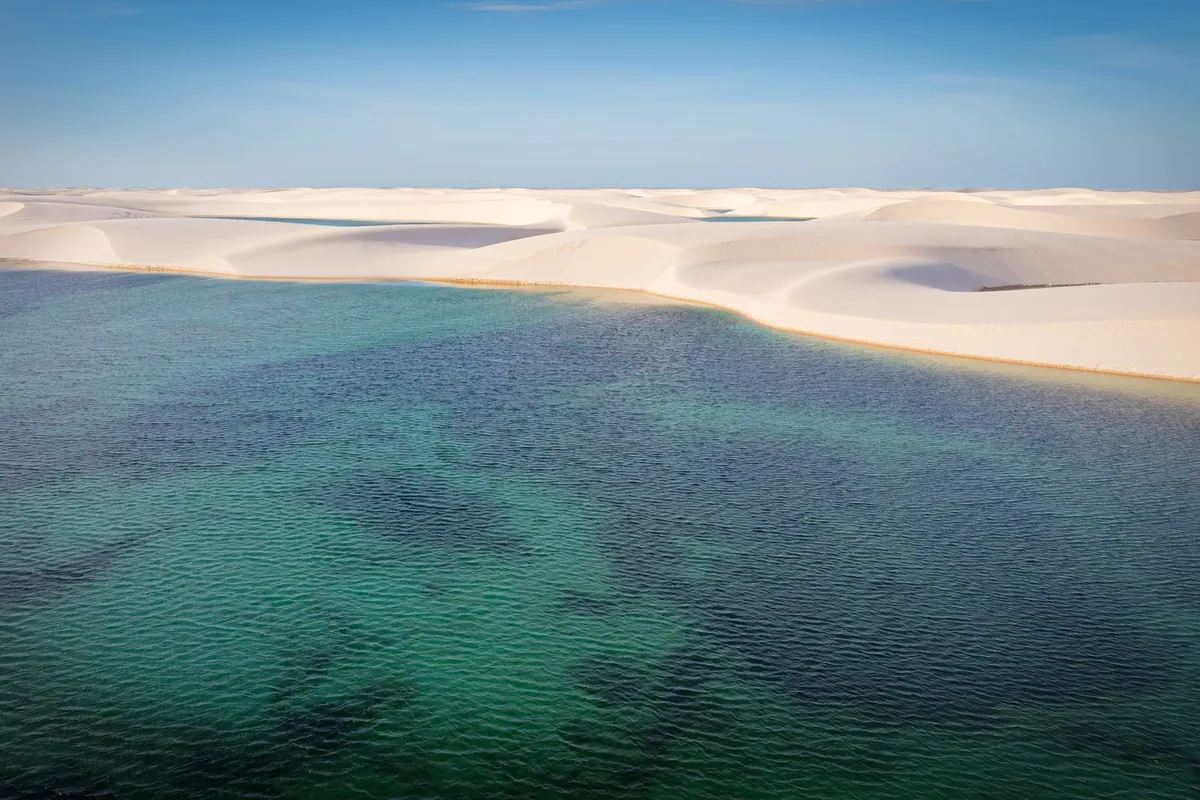 Lagoa cercada por dunas no Ceará