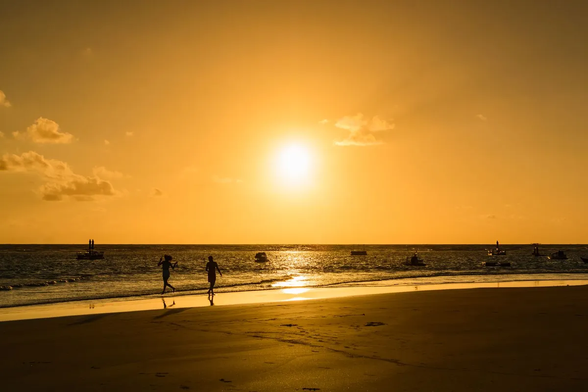 Casal observa o pôr do sol na Praia de Maracaípe