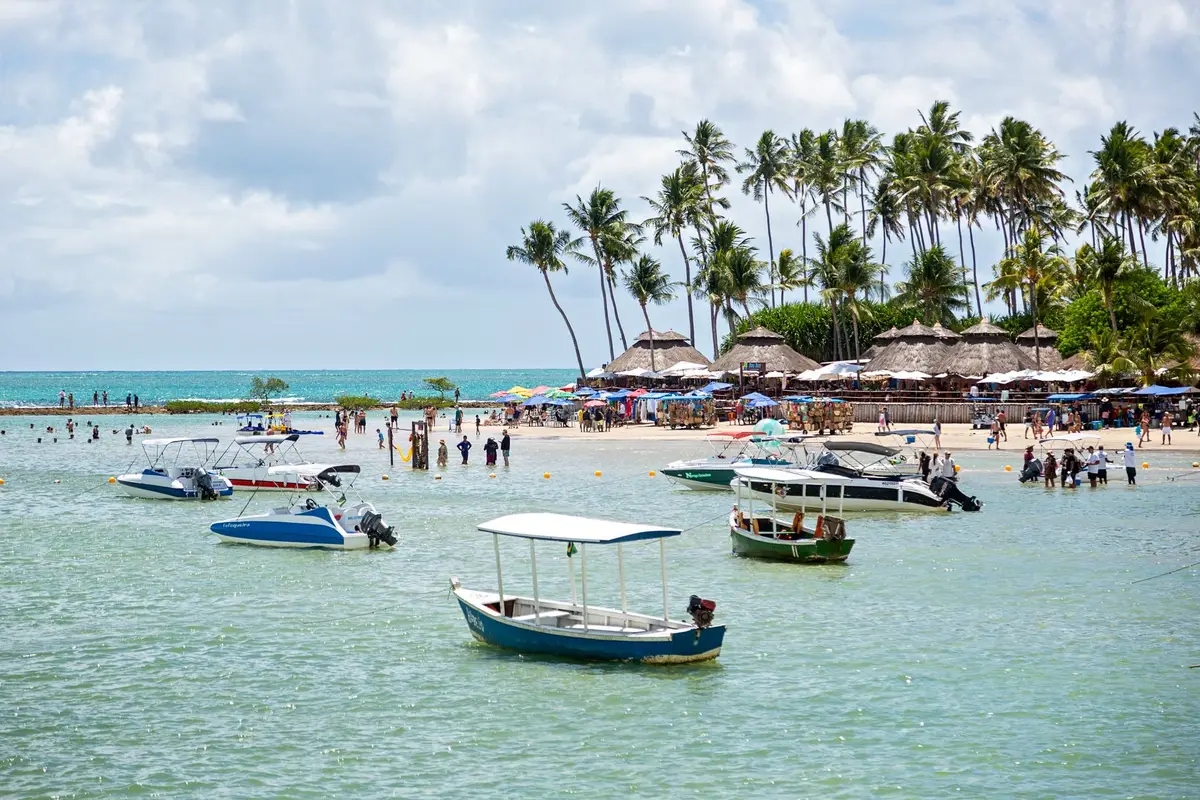 Praia de Maracaípe com barcos e coqueiros no litoral de Pernambuco