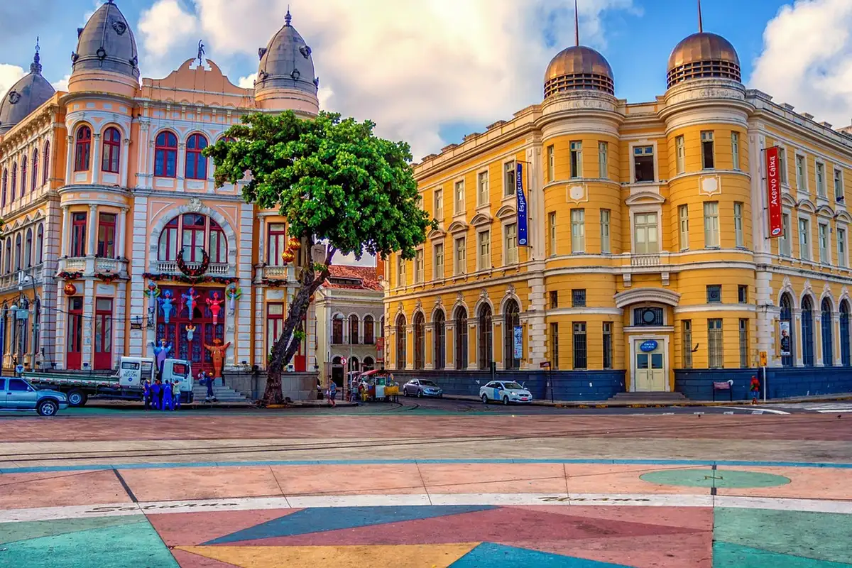 Marco Zero do Recife iluminado no fim do dia com a praça e edifícios ao redor