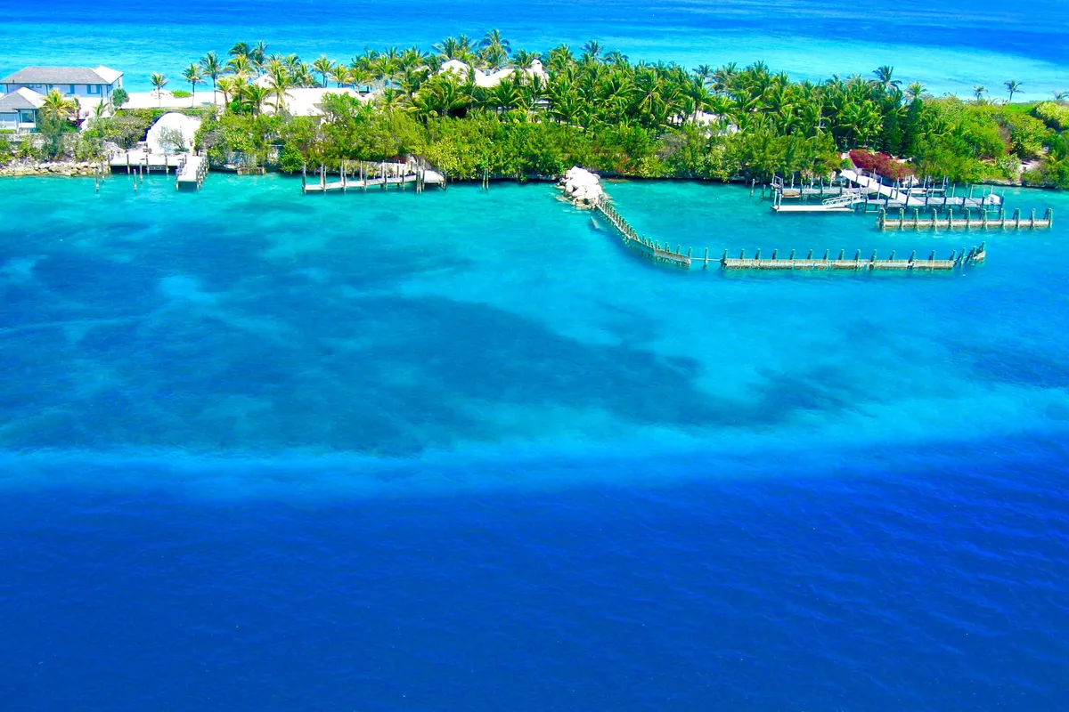 Ilha tropical cercada por água cristalina perto de Nassau, Bahamas