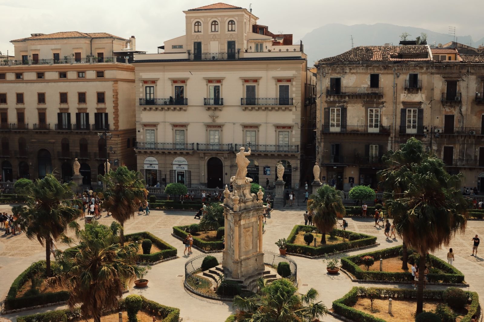 Praça histórica no centro de Palermo com jardins e edifícios antigos