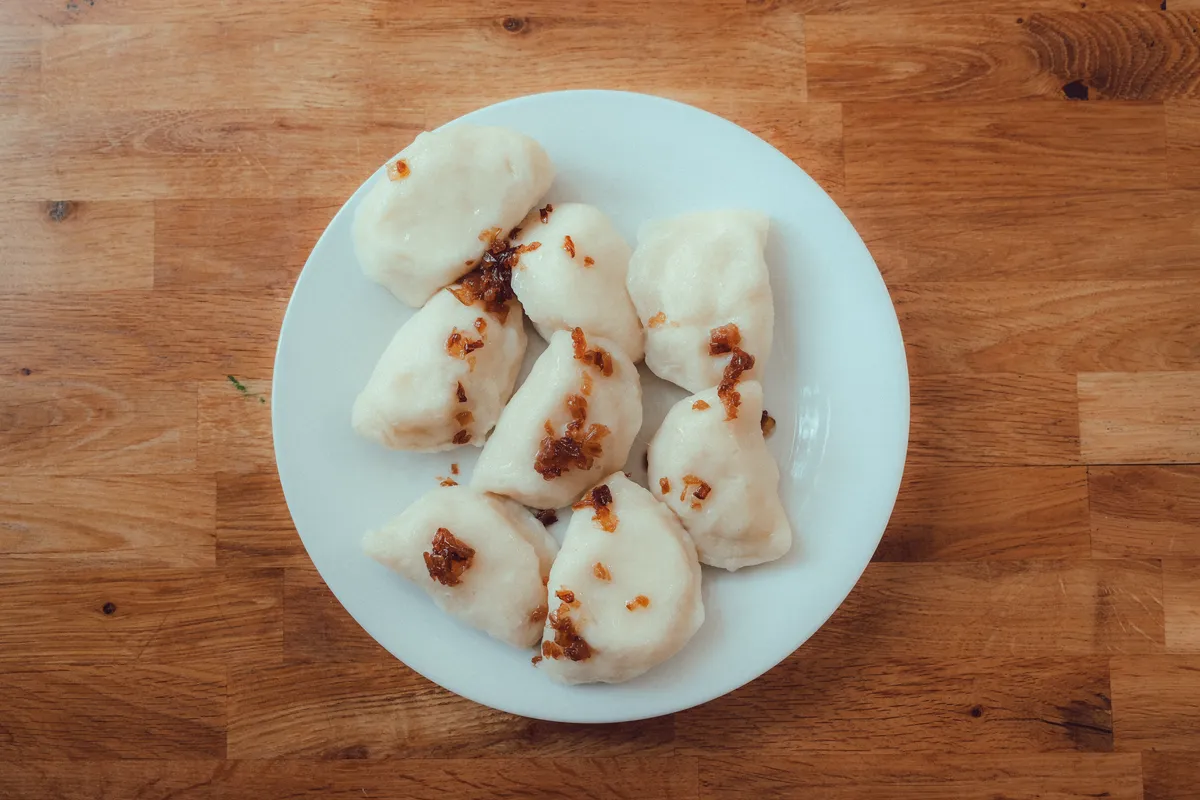 Prato de pierogi tradicionais poloneses servidos com acompanhamentos
