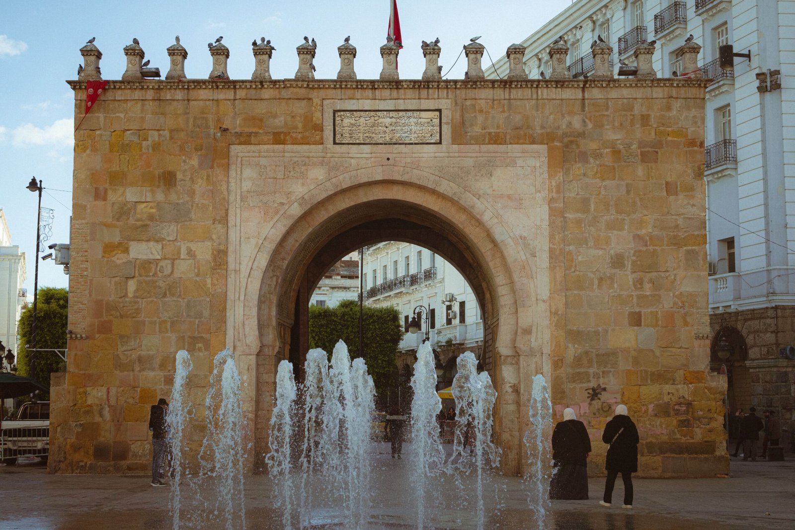 Porta histórica Bab el Bhar em Túnis, Tunísia, com fonte em frente