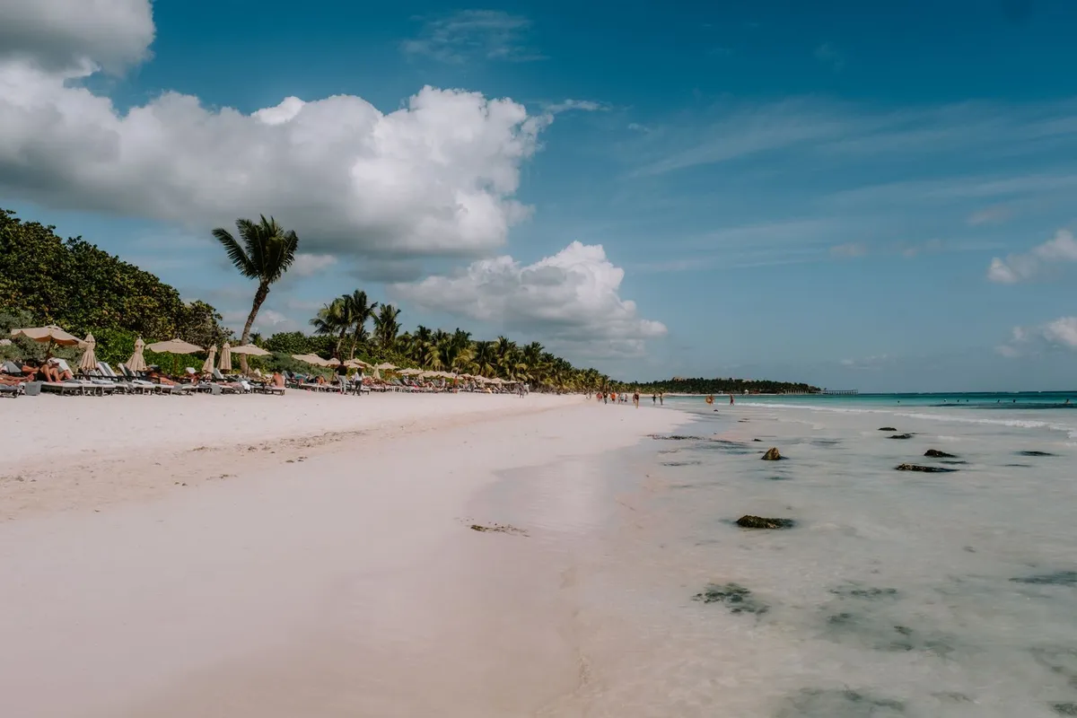 Praia de Tulum com areia branca, palmeiras e mar turquesa