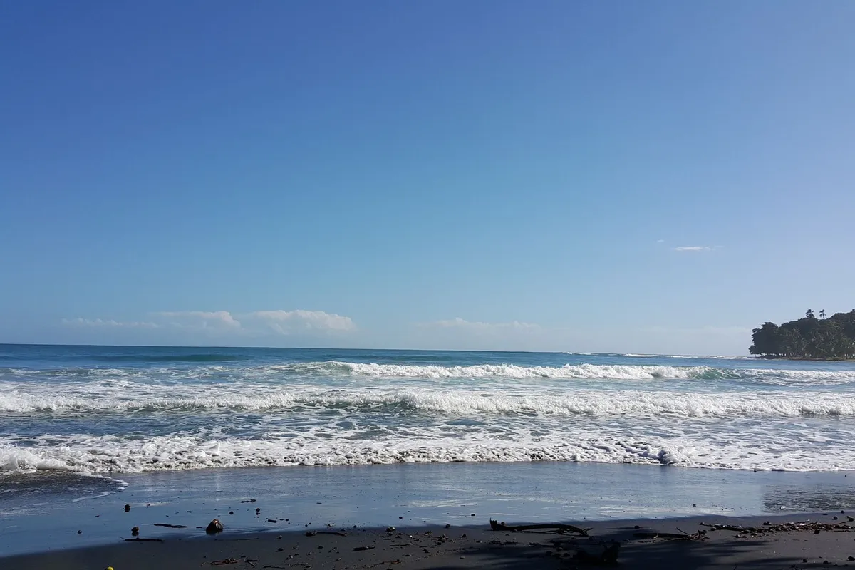Praia da Costa Rica com ondas e vegetação costeira