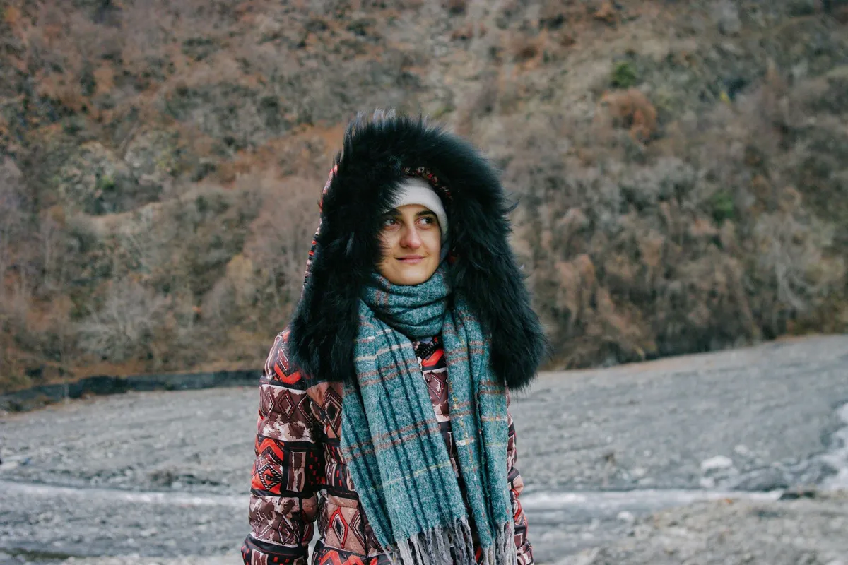 Pessoa vestida em camadas para frio em paisagem de montanha