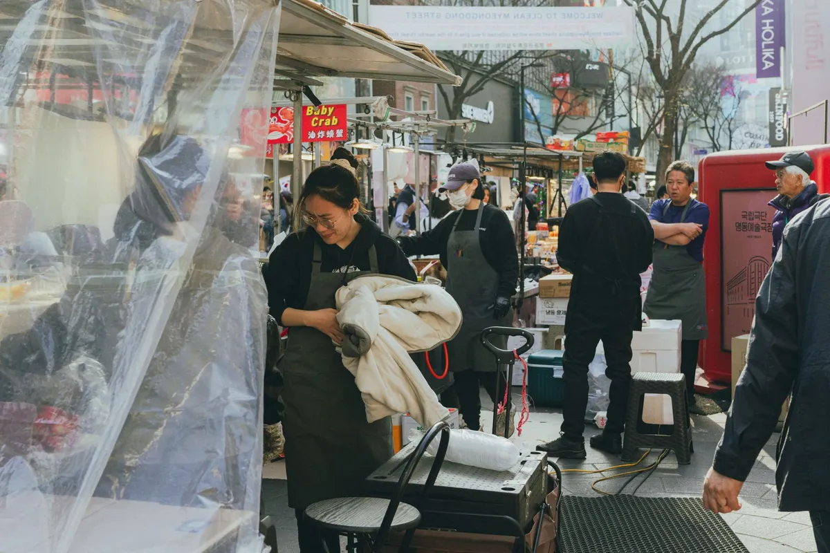 Rua movimentada de Myeongdong com lojas e letreiros em Seul