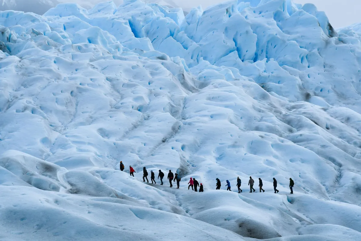 Grupo fazendo trekking na Patagônia com paisagem de montanha