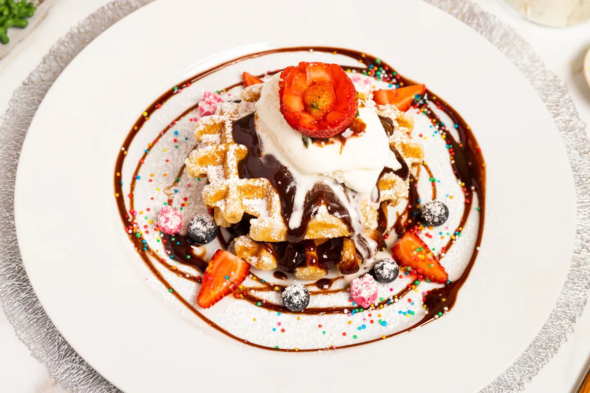 Waffle belga coberto com chocolate e frutas vermelhas