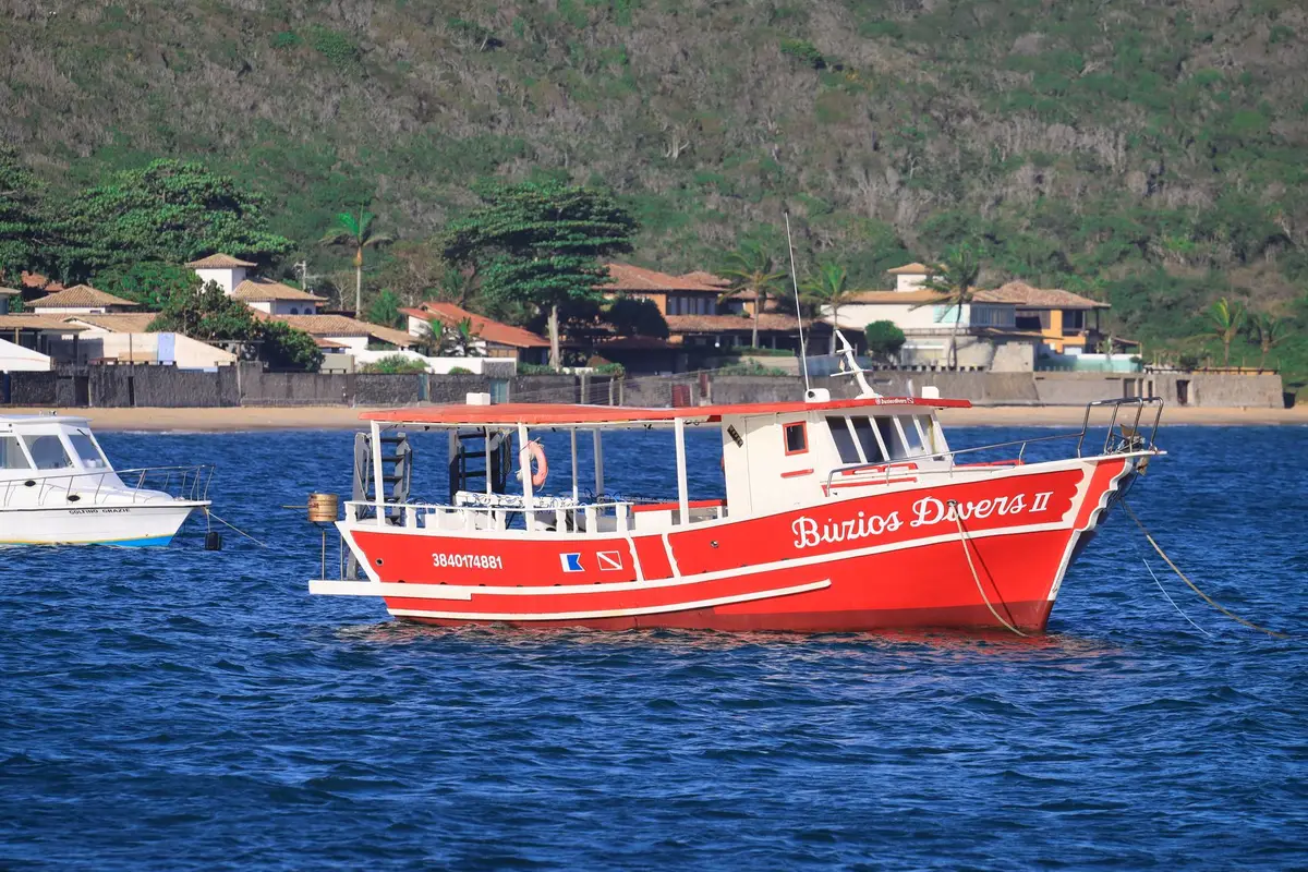 Barco de mergulho vermelho ancorado no litoral de Búzios