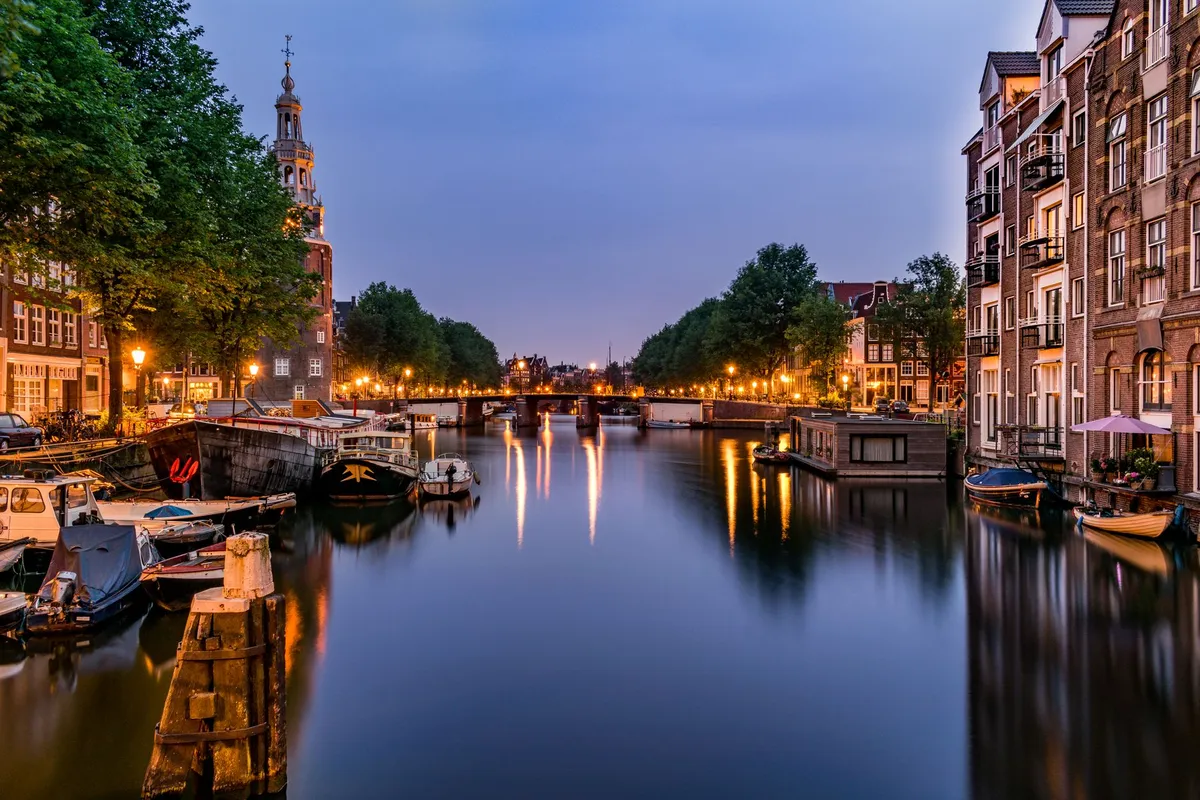 Canales históricos de Ámsterdam reflejando casas coloridas al atardecer