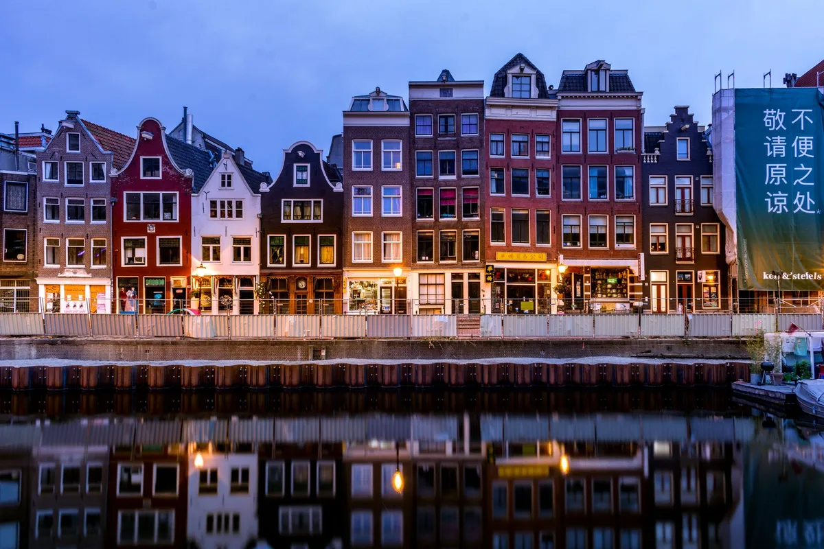Canaux historiques d'Amsterdam reflétant les maisons colorées au crépuscule