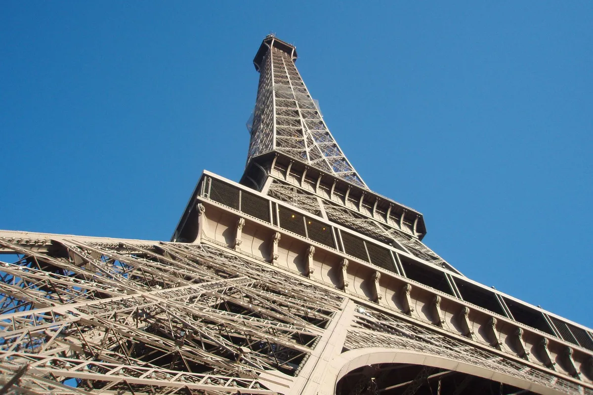 Torre Eiffel vista de baixo contra o céu azul