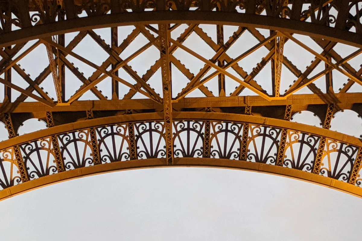 Detalhe da estrutura metálica ornamentada da Torre Eiffel