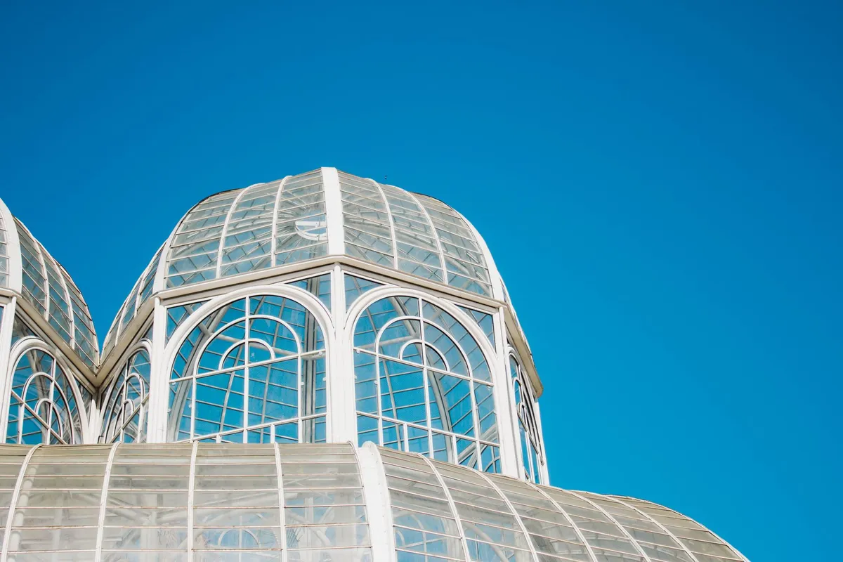 Estufa de vidro do Jardim Botânico de Curitiba com jardins floridos ao redor