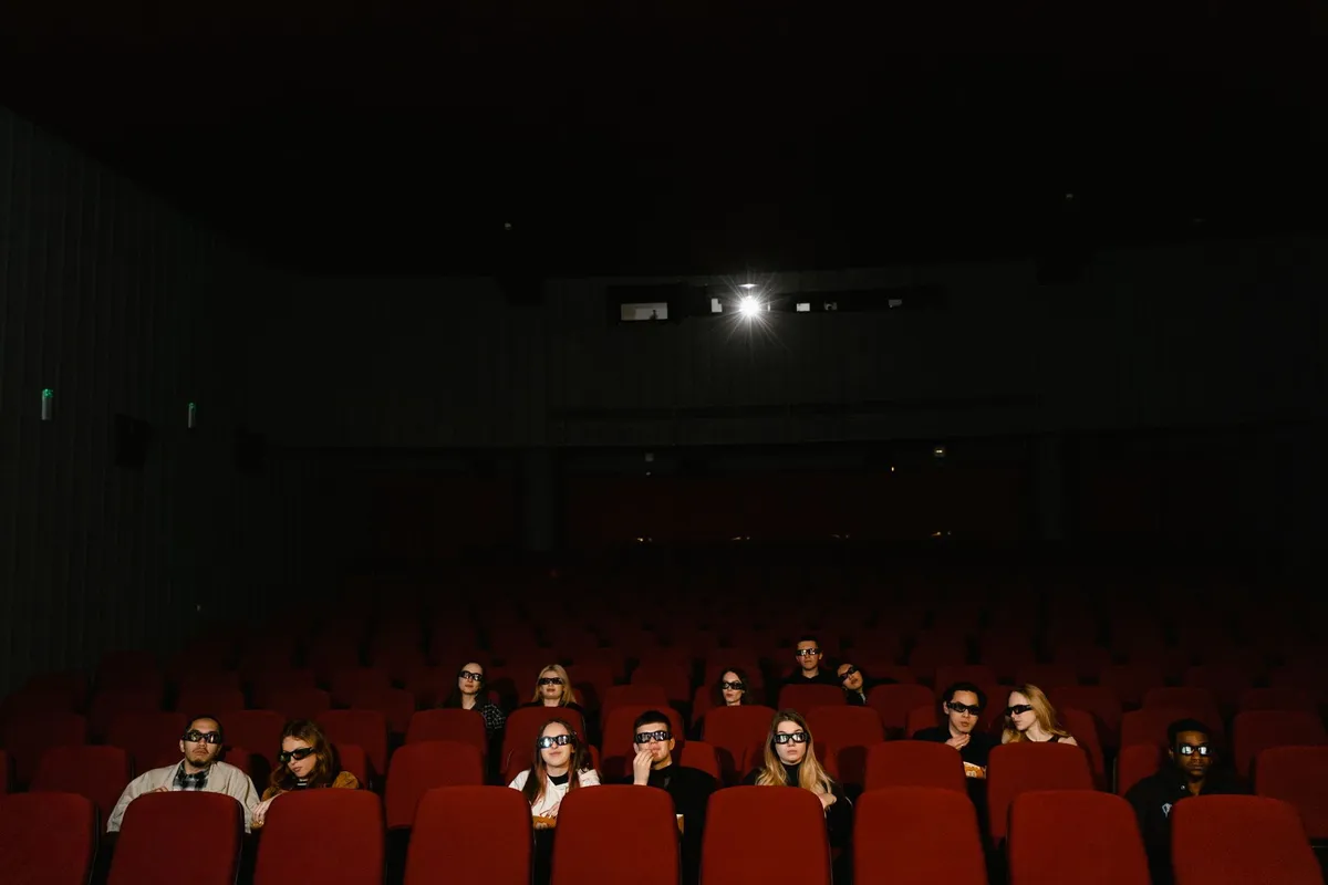 Público assiste a uma sessão de cinema em sala escura