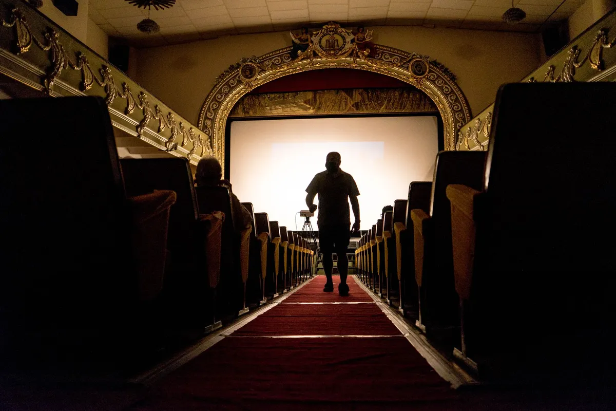 Corredor de cinema com tapete vermelho diante da tela
