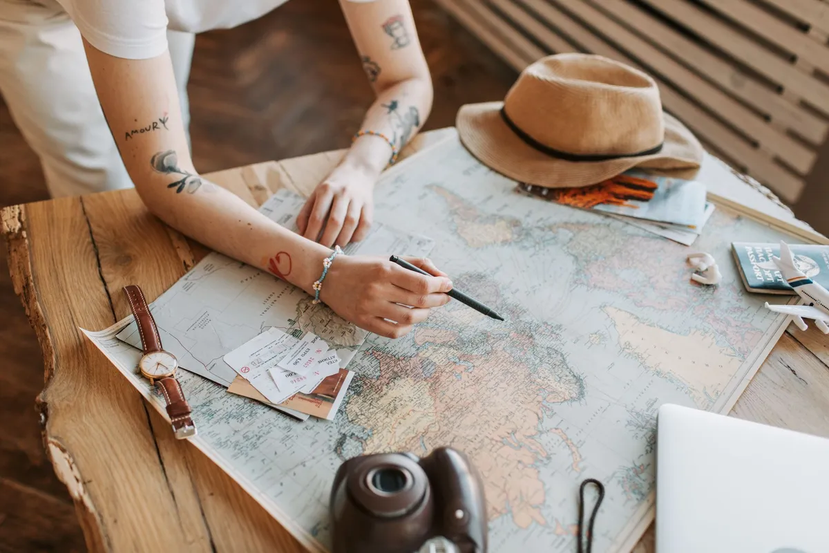 Mulher consultando um mapa-múndi para planejar roteiro