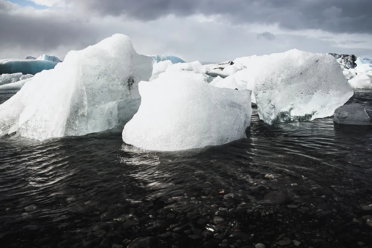 Icebergs e montanhas em lagoa da Islândia