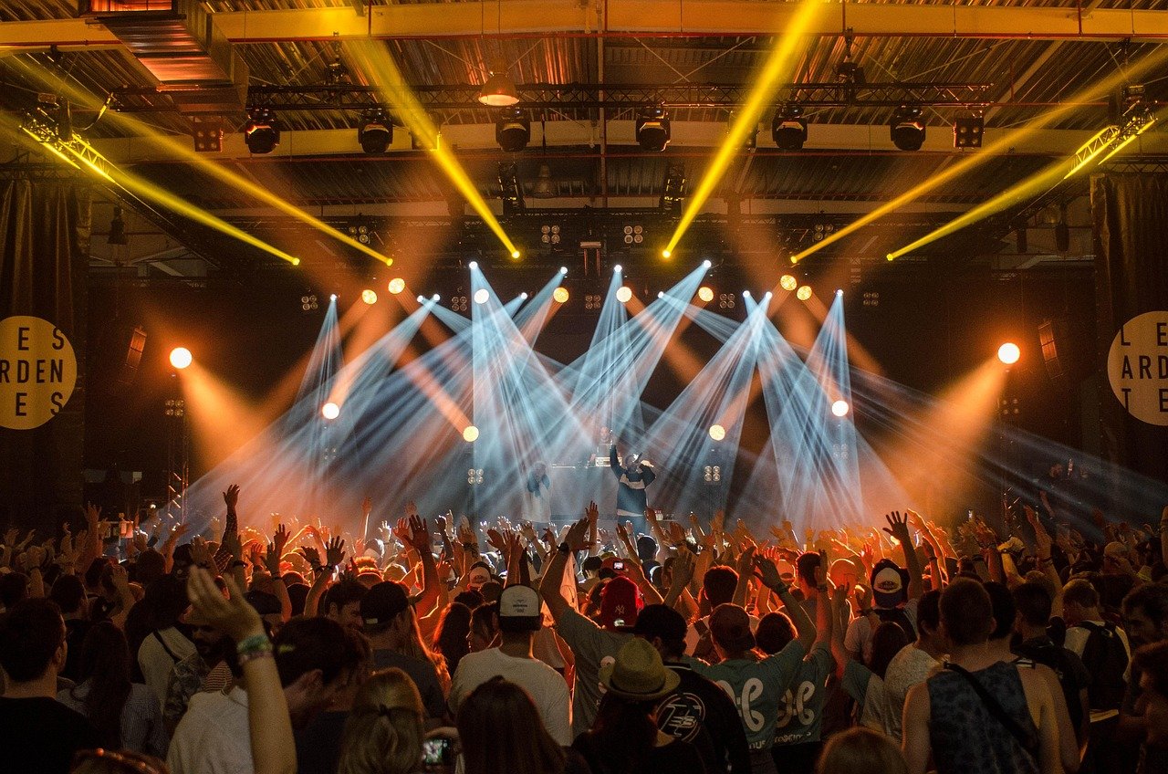 Multidão em show de festival de música com luzes de palco ao fundo