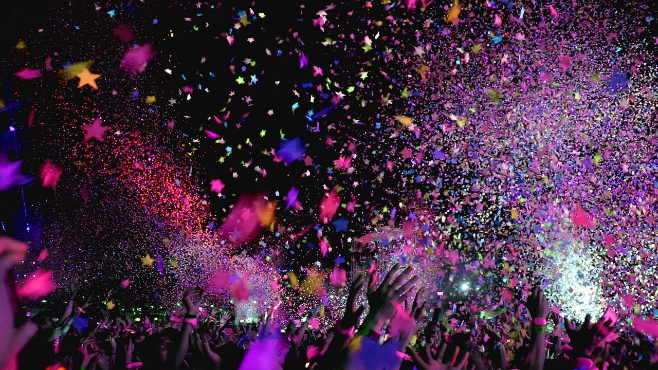 Show ao vivo com confete e publico celebrando em festival de musica