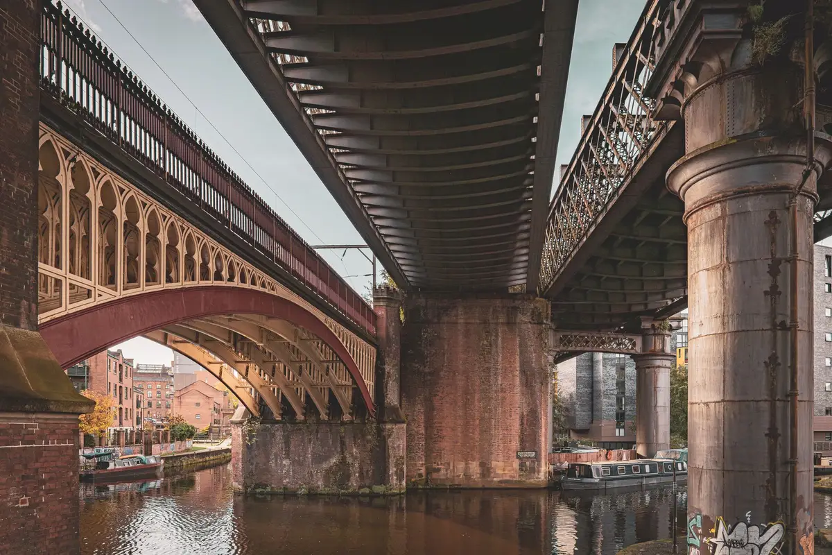 Canais de Castlefield com arquitetura industrial e skyline de Manchester