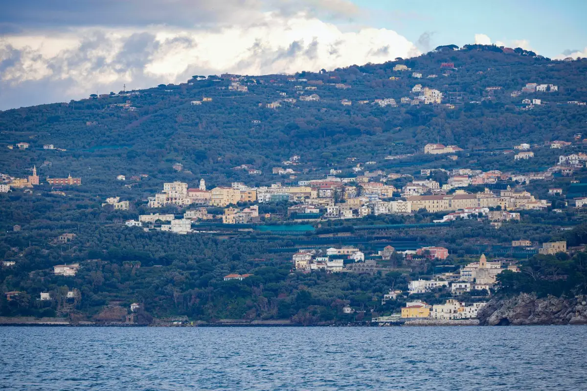 Vila costeira do Mediterrâneo vista do alto, com casas e mar azul