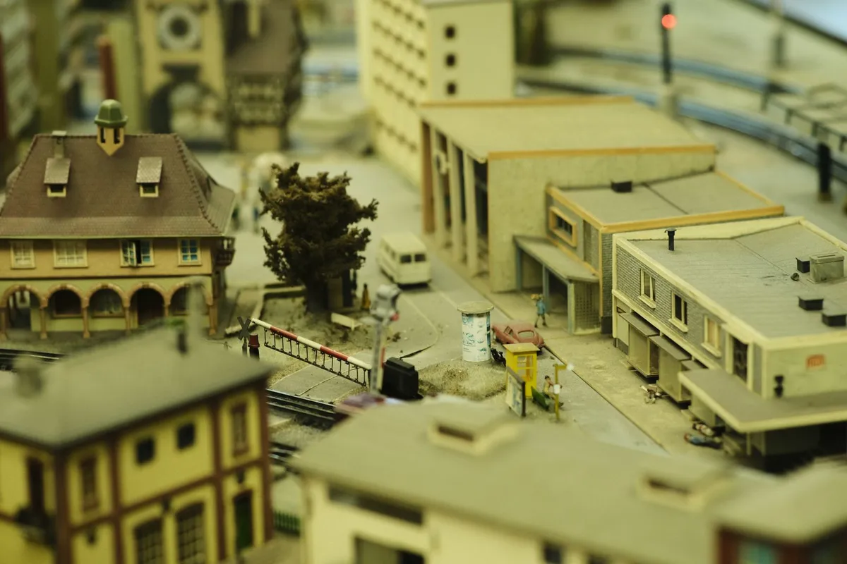 Miniatura detalhada de cidade com prédios e ferrovia, parecida com o Mini Mundo