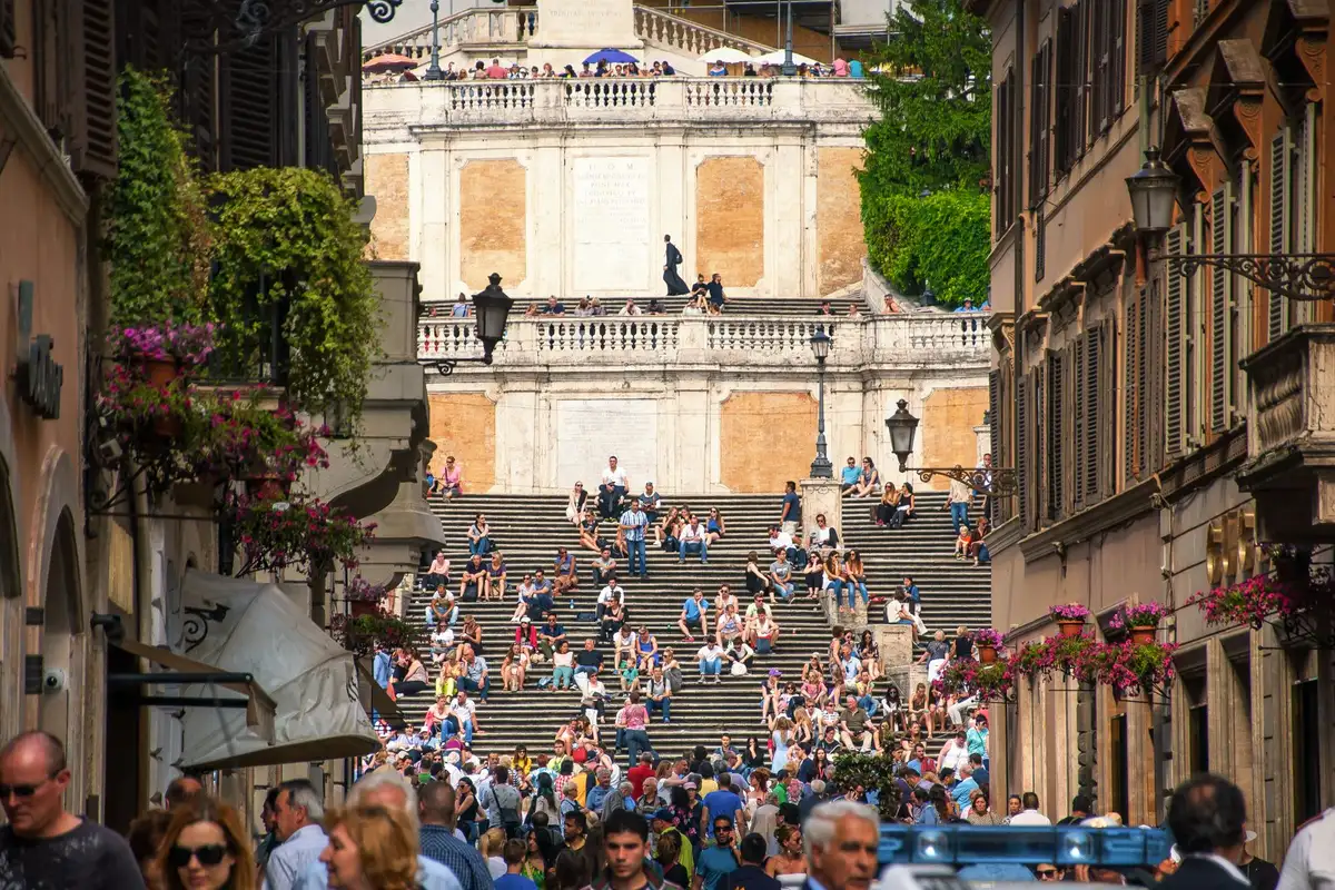 Rua de paralelepípedos com pessoas caminhando no bairro Monti, Roma